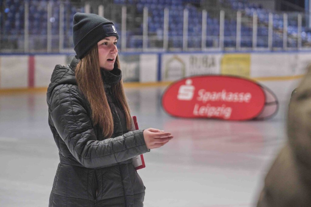 Mitarbeiterin betreut Gäste beim Eisstockschießen im anona Icedome Leipzig